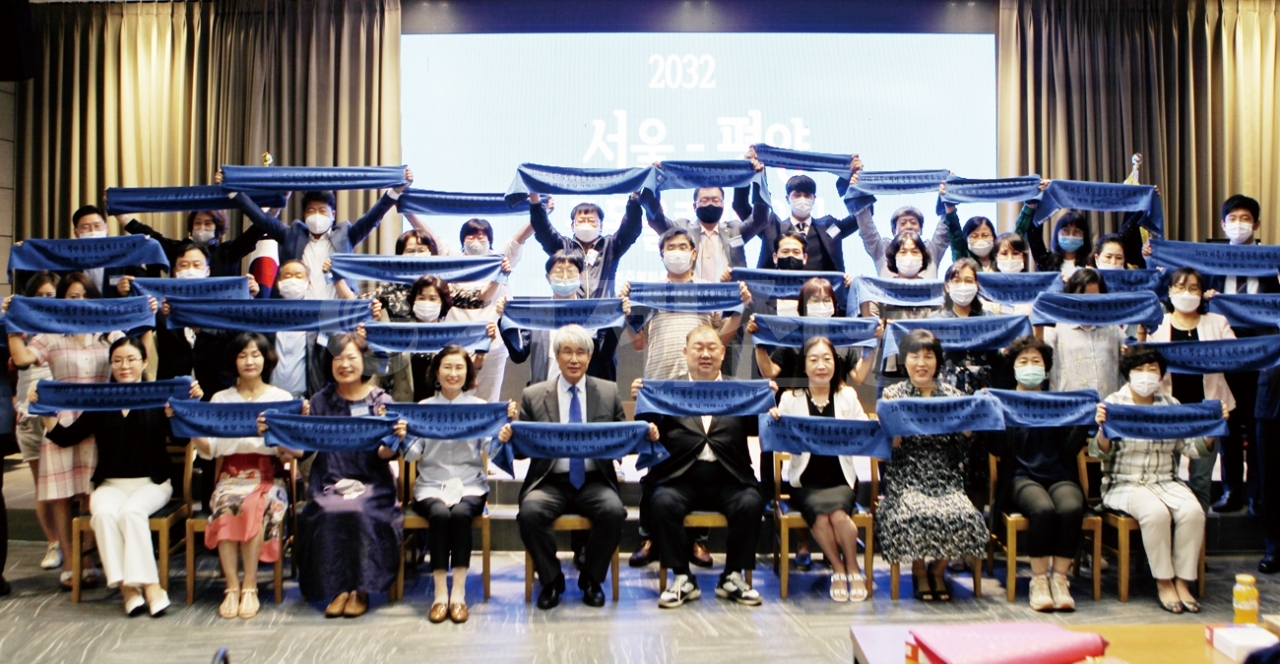 지난 24일 민주평통 거제시협의회가 통일시대 시민교실 제3기 평화경제·통일아카데미 마지막 강의 후 수료식에서 모든 참석자들이 '2032 서울·평양 공동올림픽 유치'를 기원하며 퍼포먼스를 펼치고 있는 모습.