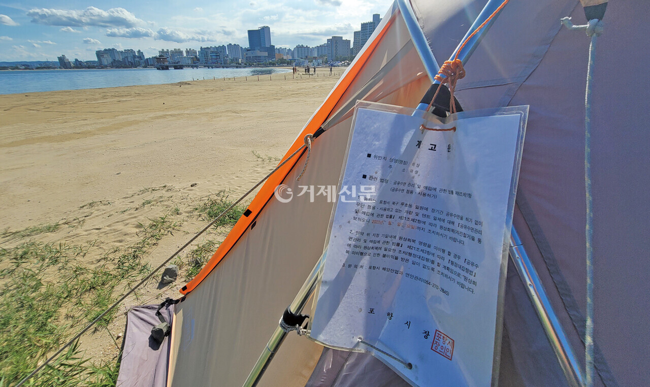 포항시 영일대해수욕장에 불법으로 설치된 텐트,  '공유수면 관리 및 매립에 관한 법률'을 준용해 텐트를 철거하라는 포항시 해양산업과의 계고문이 붙어 있다. /사진= 최대윤 기자