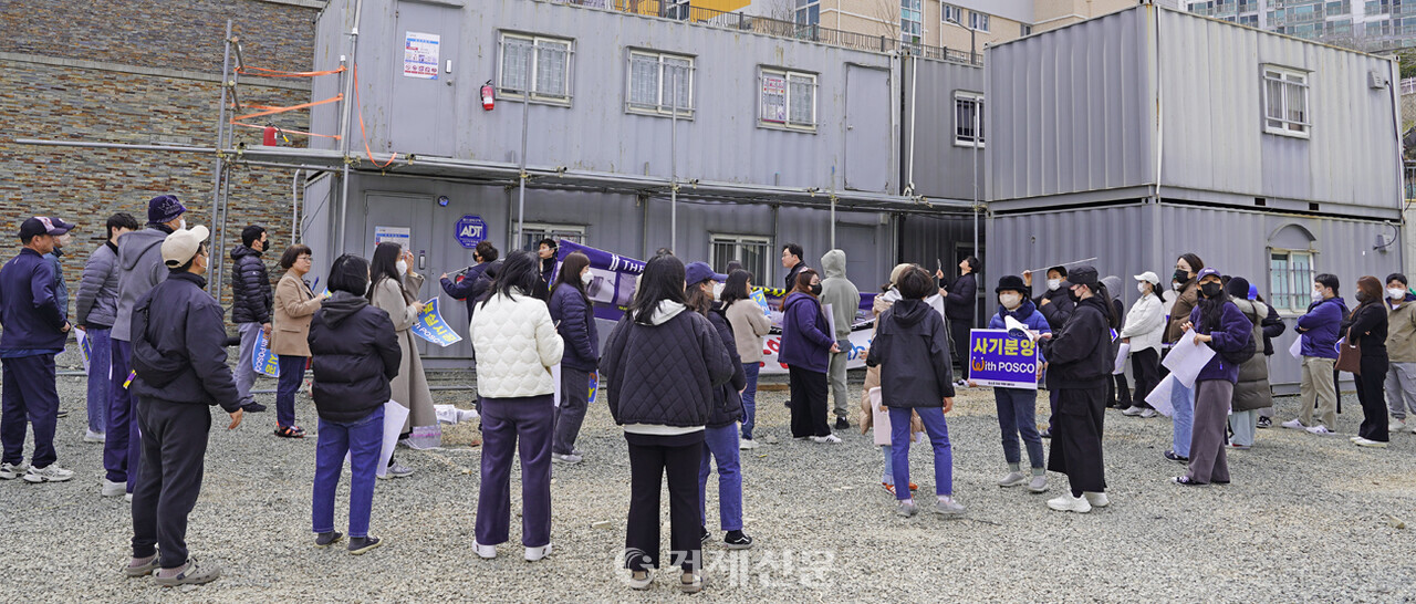지난 22일 상동 더샵디클리브 아파트 입주민 40여명이 묘지뷰와 미시공된 물품·새시 불량 등의 하자 문제를 해결하라며 더샵디클리브 현장사무실 앞에서 규탄 집회를 열고 있다. @조민정
